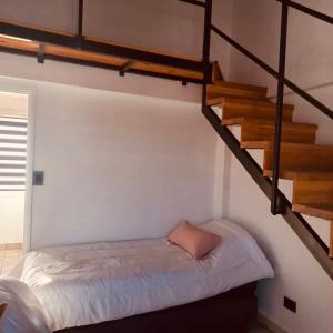 a bedroom with a bed and a staircase at USHUAIA MG in Ushuaia
