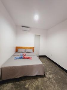 Un dormitorio con una cama con dos pares de tijeras. en HYD Hostel Moalboal, en Moalboal