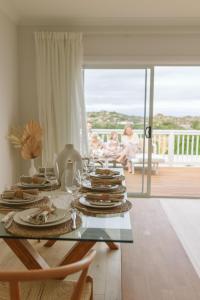 a dining room with a table with plates of food at Beyond Beach House in Goolwa South