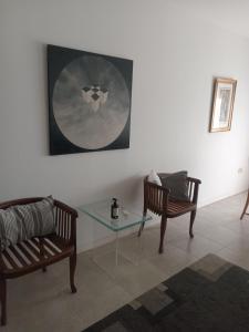 sala de estar con 2 sillas y mesa de cristal en Departamento Verbenas Céntrico con cochera, en Santa Rosa