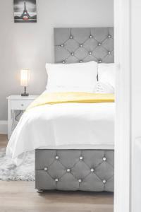 a bedroom with a white bed with a metal headboard at Pass the Keys Modern Flat near Tower Bridge in London