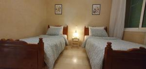 馬拉喀什的住宿－Cozy apartment in the heart of marrakech，一间卧室配有两张单人床和一盏灯。