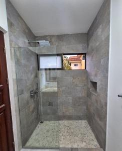 a bathroom with a shower with a window at Beautiful newly refurbished 2 bedroom 2 Bathroom 2nd floor condo in Tamarindo