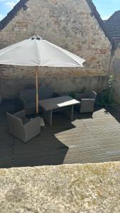une table et des chaises avec un parasol sur une terrasse dans l'établissement Appartement avec terrasse, à Vierzon