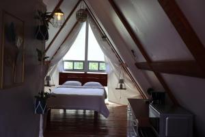 Boquete Firefly Inn في بوكيتي: غرفة نوم بسريرين في العلية