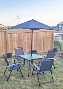 a table and chairs with an umbrella in a yard at Cozy Private Suite in Winnipeg