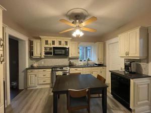 a kitchen with white cabinets and a ceiling fan at THE RED dragon in Niagara Falls