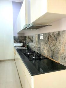 - une cuisine avec un comptoir noir et une cuisinière dans l'établissement HOUSE IN SURAKARTA, à Grogol