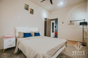 um quarto com uma cama grande e almofadas azuis em Ipoh Fumei 2R2B House 1 by Verve Pasir Pinji em Ipoh