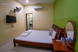 a bedroom with a bed and a mirror and a television at Sea House in Ấp Bình Hưng +99 photos