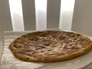 a pizza sitting on top of a white plate at E Lodge in Islamabad