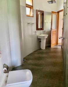 a bathroom with a toilet and a sink at Senu Lagoon Villa in Tangalle