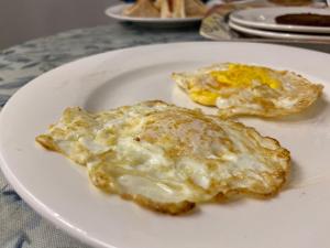 two fried eggs on a white plate on a table at E Lodge in Islamabad