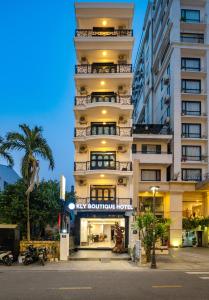 um edifício alto e branco com uma placa que lê o novo boutique hotel em Kly Boutique Hotel em Hue