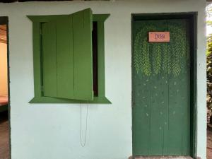 a green door and window with a sign on it at Casa Mamré in Cahuita +23 photos