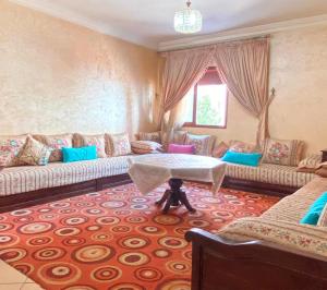 Charming house في أغادير: غرفة معيشة مع أريكة وطاولة
