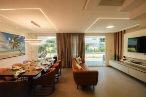 ein Esszimmer mit Tisch und Stühlen und einem Fernseher in der Unterkunft Casa em Maragogi/AL in Maragogi