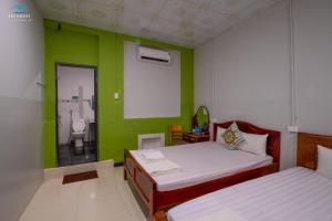 1 Schlafzimmer mit 2 Betten und einer grünen Wand in der Unterkunft Sea House in Ấp Bình Hưng