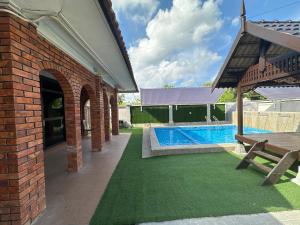a brick house with a swimming pool in a yard at Mawar 23 Chendering with Private Pool in Kuala Terengganu +35 photos