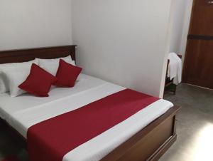 a bed with red and white pillows in a room at Villa 39 Katunayake Airport transit villa in Katunayake