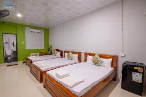 2 Betten in einem Zimmer mit grünen Wänden in der Unterkunft Sea House in Ấp Bình Hưng