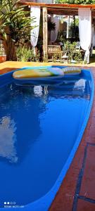 a swimming pool with a blue and yellow object in it at Pousada Ray Sol - Centro Arraial d Ajuda in Porto Seguro