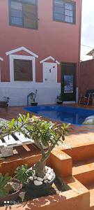 a bonsai tree in front of a building with a swimming pool at Pousada Ray Sol - Centro Arraial d Ajuda in Porto Seguro