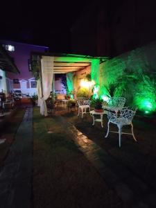 a patio with a table and chairs at night at Pousada Ray Sol - Centro Arraial d Ajuda in Porto Seguro