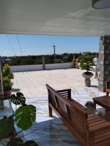 een houten bank op een terras met een witte tent bij Villa De Gracia in Manilla +10 foto's