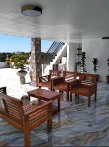 een groep houten banken in een kamer met een trap bij Villa De Gracia in Manilla