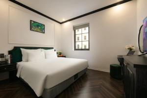 Un dormitorio con una gran cama blanca y una ventana en Elegant Boutique Hotel Ha Long, en Ha Long