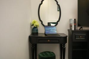 a black table with a mirror and a laptop on it at Elegant Boutique Hotel Ha Long in Ha Long