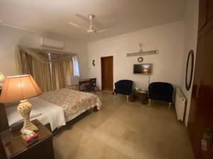 sypialnia z łóżkiem i stołem z lampką w obiekcie E Lodge w mieście Islamabad