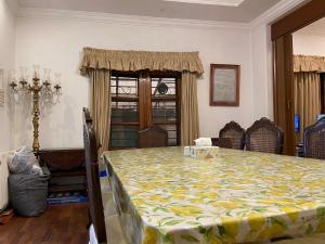 a room with a table and chairs and a window at E Lodge in Islamabad