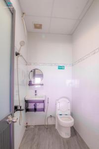 a small bathroom with a toilet and a sink at Sea House in Ấp Bình Hưng