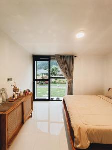 a bedroom with a bed and a large window at Ginastro Hom in Bangli