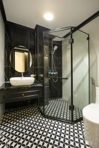 a black bathroom with a sink and a mirror at Elegant Boutique Hotel Ha Long in Ha Long