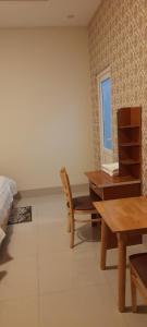 um quarto com uma cama, uma mesa e cadeiras em Nhà nghỉ Kim Cương em Rạch Giá