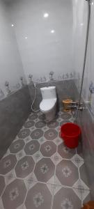 a bathroom with a toilet and a red bucket at Nhà nghỉ Kim Cương in Rạch Giá