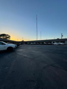 a parking lot with cars parked in front of a building at Economy Inn in Ada