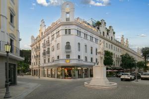 a white building with a statue in front of it at Elegant Boutique Hotel Ha Long in Ha Long