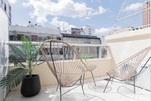 a balcony with two chairs and a potted plant at Segui 3900 'b' - Loft Palermo Chico in Buenos Aires