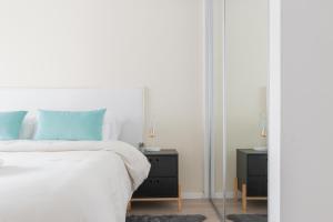 1 dormitorio con cama blanca y espejo en Fliphaus Zapiola 2300 'b' - 1 Bd Belgrano en Buenos Aires