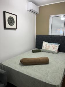Una cama con una almohada marrón encima. en Casa do Zafer en São Paulo