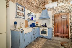 a kitchen with blue cabinets and a blue oven at Byzantine Home in the Castle in Mesta