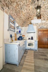 a kitchen with white appliances and a brick wall at Byzantine Home in the Castle in Mesta