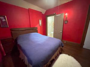 a bedroom with red walls and a blue bed at THE RED STAR ROOM A in Niagara Falls