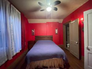 una camera rossa con letto e ventilatore a soffitto di THE RED STAR ROOM A a Niagara Falls
