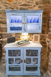a blue cabinet with glass doors and a table at Byzantine Home in the Castle in Mesta