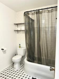 La salle de bains est pourvue de toilettes et d'un rideau de douche. dans l'établissement Modern, Bright 2BR Casita in Vibrant Echo Park Silver Lake with Gourmet Kitchen and Unbeatable Proximity to LA Hotspots, à Los Angeles